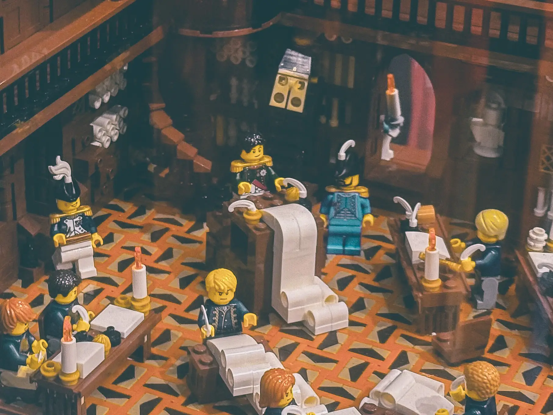 LEGO build of a candlelit council chamber where Napoleon presents the Civil Code on an oversized scroll.