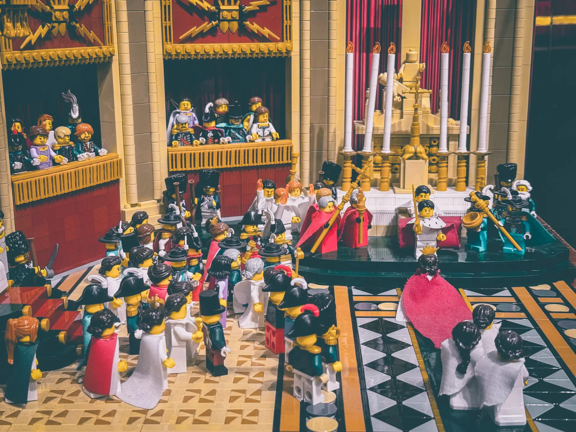 LEGO recreation of Napoleon's coronation at Notre-Dame, with crowded galleries, red drapery and the imperial party on the black-and-white tiled floor.