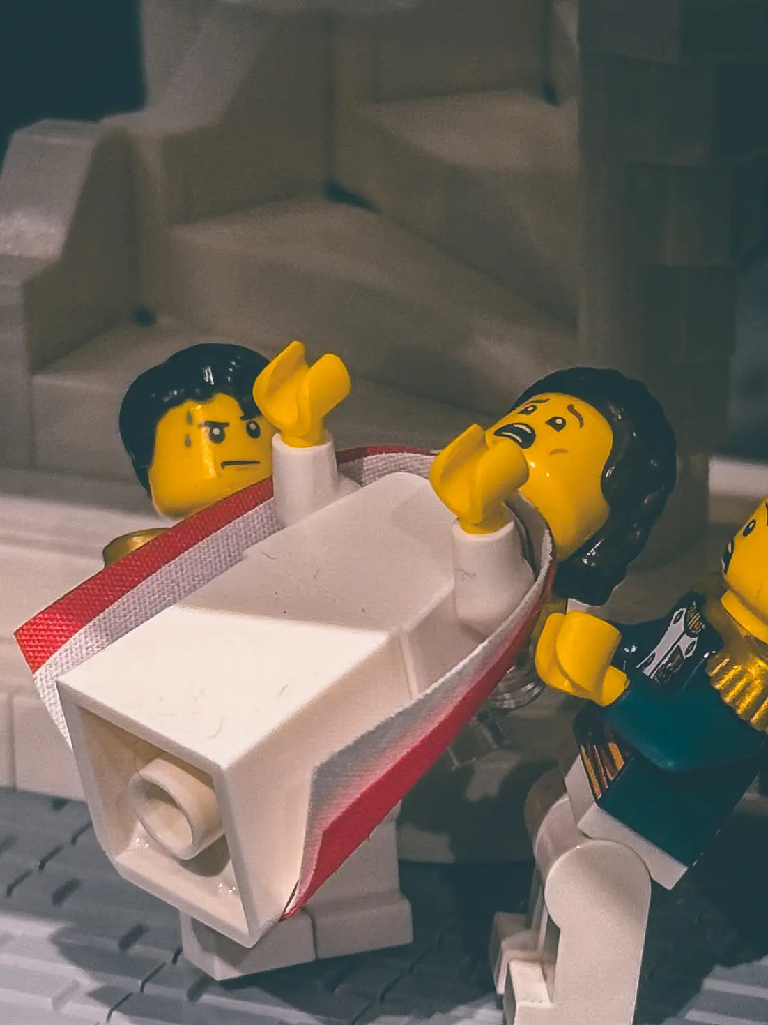 Close view of the LEGO divorce scene: a Joséphine minifigure collapsing backwards over a white chaise while Napoleon stands over her.
